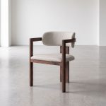 Eetkamerstoel japandi met armleuning en een walnoot frame en een taupe kleurige zitting.