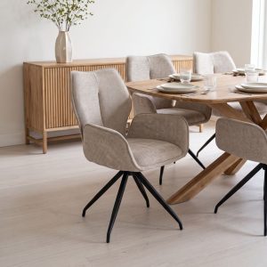 Beige draaistoel aan een houten eettafel in een licht Scandinavisch interieur