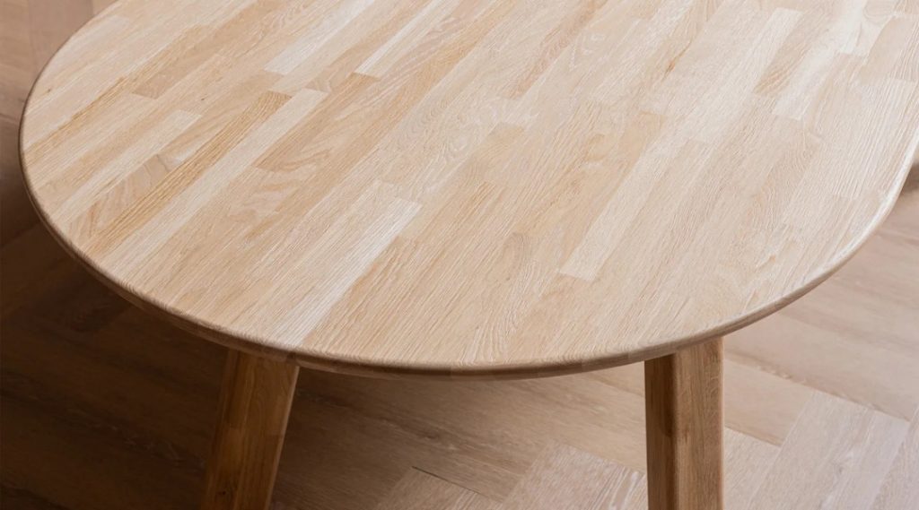 Detail foto van het tafelblad van ovale eettafel Tablo van HUUS gemaakt van eikenhout.