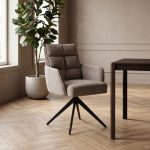 Armstoel Rosora van Tower Living in beige met zwarte metalen poten, gestyled aan een eettafel in een modern interieur.